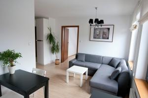 a living room with a couch and a table at Apartamenty Mesa Grill Restaurant Cafe in Dźwirzyno