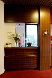 eine Theke mit einem Fenster und einer Vase aus Blumen in der Unterkunft Hotel Garni Centro in Chiasso
