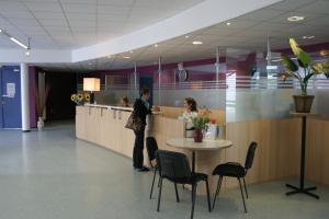 a man standing at a counter in an office at Ethic Etapes CIS de Besançon in Besançon