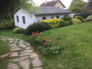 a garden with red flowers and a house at Ferien Haus bei Wien in Hagenbrunn