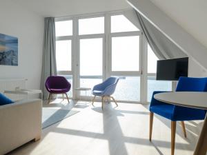 sala de estar con mesa y sillas azules y moradas en Haus Marinas, en Helgoland