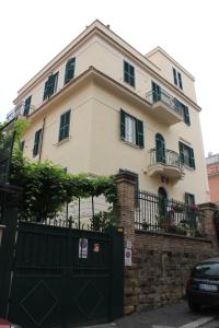 uma grande casa branca com um portão preto em Casa per Ferie Beato Rosaz em Roma