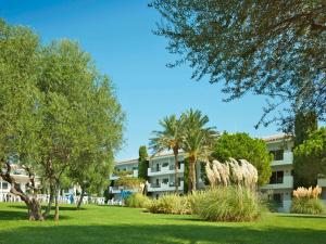 budynek w parku z drzewami i trawą w obiekcie Inturotel Azul Garden w mieście Cala d´Or