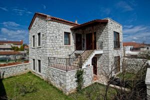 a stone house with a balcony on a yard at İncekara in Alacati