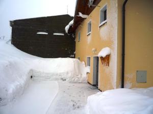 un callejón cubierto de nieve junto a un edificio en Apartmány Cestář Boží Dar, en Boží Dar