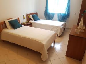 Duas camas num quarto com uma janela em Apartamento Silva em Albufeira