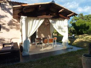 pérgola con mesa y sillas en el patio en Villa Elysae, en Mougins