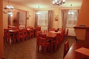 a dining room with wooden tables and chairs at Pensiunea Maria Köber in Gura Rîului