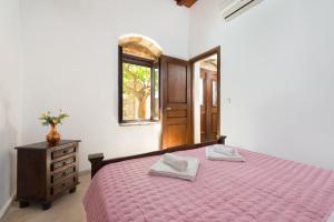 a bedroom with a bed and a dresser and a window at Villa Claudia in Lardos in Lartos