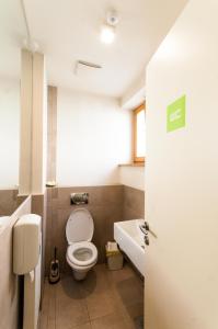 a bathroom with a toilet and a sink and a tub at CUBE central rooms for 2 in Ljubljana