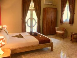 Un pat sau paturi într-o cameră la Ada Waktu Homestay