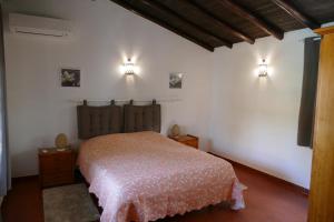 a bedroom with a bed and two lights on the wall at Quinta Falzina in Luz +35 photos