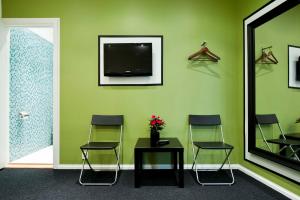una sala d'attesa con tre sedie, un tavolo e una TV di Stockholm Hostel a Stoccolma