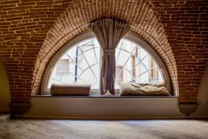 an arch window with a vase in a brick wall at N4U Guest House Florence in Florence