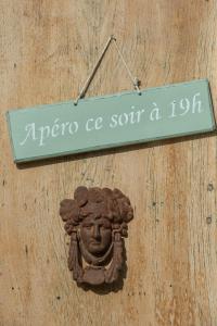 a sign hanging on a wall with a face on it at Les Carmes and spa in Le Thor