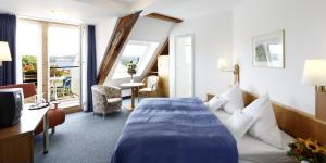 a hotel room with a bed and a window at Insel-Hof Reichenau Hotel-garni in Reichenau