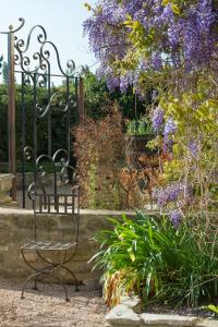 a wrought iron chair sitting in front of a garden at Les Carmes and spa in Le Thor