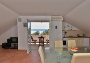 eine Küche und ein Esszimmer mit einem Glastisch in der Unterkunft Apartments Mila - Mala Duba in Živogošće