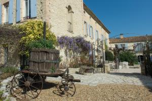 a wooden cart with a planter on it in front of a building at Les Carmes and spa in Le Thor