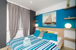 1 dormitorio con 1 cama grande y paredes azules en Apartments Zore Glavinić, en Dubrovnik