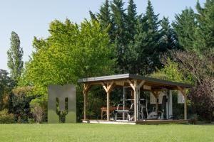 a gazebo in the middle of a lawn at Les Carmes and spa in Le Thor