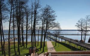 een brug over een waterlichaam met bomen en banken bij Luksusowy apartament z widokiem na jezioro in Giżycko