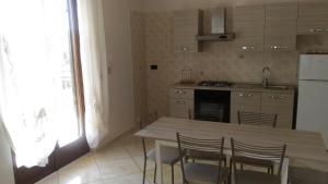 a kitchen with a table and chairs and a refrigerator at SWEET HOME GIULIA Locazione ad uso turistico in Cimitile