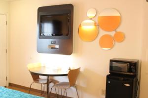 a room with a table and a tv on the wall at Howard Johnson by Wyndham Lake George in Lake George