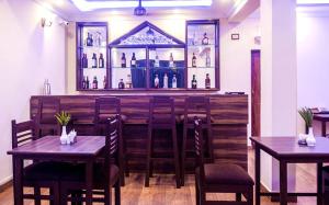 a restaurant with tables and chairs and a bar at Eve Resort in Patnem