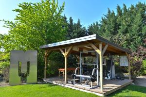 a gazebo with a bench in the grass at Les Carmes and spa in Le Thor