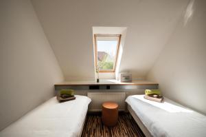 2 łóżka pojedyncze w pokoju z oknem w obiekcie CUBE central rooms for 2 w Lublanie