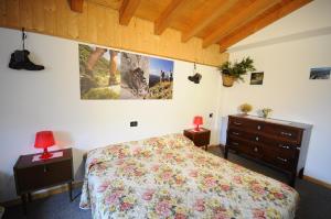 a bedroom with a bed and a painting on the wall at Belvedere Mountain Experience in Monno