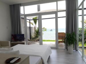 a bedroom with two beds and a view of the ocean at TS Beach House in Phú Quốc