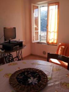 a living room with a table with a television and a basket at Alloggio Lavanda in Diano San Pietro