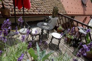 a patio with a table and chairs and purple flowers at Baderhaus in Bruck an der Mur