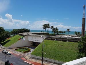 a building with a green lawn next to the ocean at Point a beira mar de Tambaú, Flat Israel 310 in João Pessoa