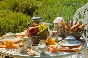 une table avec une assiette de nourriture et des paniers de pain dans l'établissement Les Carmes and spa, au Thor