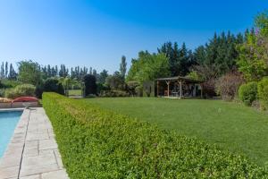 a garden with a gazebo next to a body of water at Les Carmes and spa in Le Thor