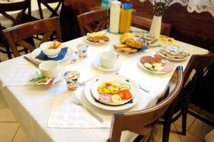 uma mesa com pratos de comida para o pequeno almoço em Corvin Panzio em Gyor