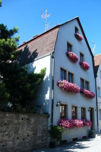 ein weißes Gebäude mit rosa Blumen auf der Seite in der Unterkunft Pension Hofmann-Schmölzer in Rothenburg ob der Tauber