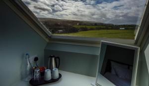 a window with a view of a green field at The Pipers Rest in Doolin