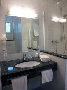 Un baño con lavabo y un espejo grande. en Pension Hofmann-Schmölzer, en Rothenburg ob der Tauber 11 fotos más