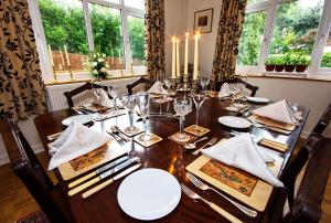a dining room table with white plates and napkins at Tresillian House in Melton Mowbray