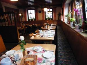 a dining room with tables and chairs in a restaurant at Pension Hofmann-Schmölzer in Rothenburg ob der Tauber