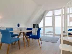 Un comedor con una mesa y sillas azules. en Haus Marinas, en Helgoland