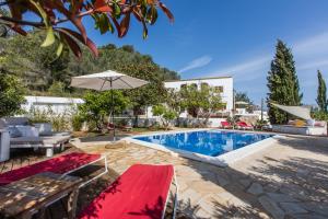 uma piscina com um cobertor vermelho e um guarda-chuva em Can Rosa Ibiza, private pool, 10 minutes from the beach em Santa Gertrudis de Fruitera