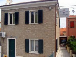 una casa de ladrillo con persianas negras en una calle en Mery's House casa vacanza 2, en Fano