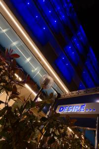 a blue lit up sign in a building with a sign at Hotel Desire' in Riccione