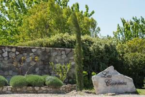 a stone wall with a sign that says ex comminas at Les Carmes and spa in Le Thor