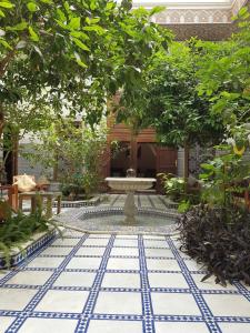 a courtyard with a fountain and trees in a building at Riad Souafine in Fez